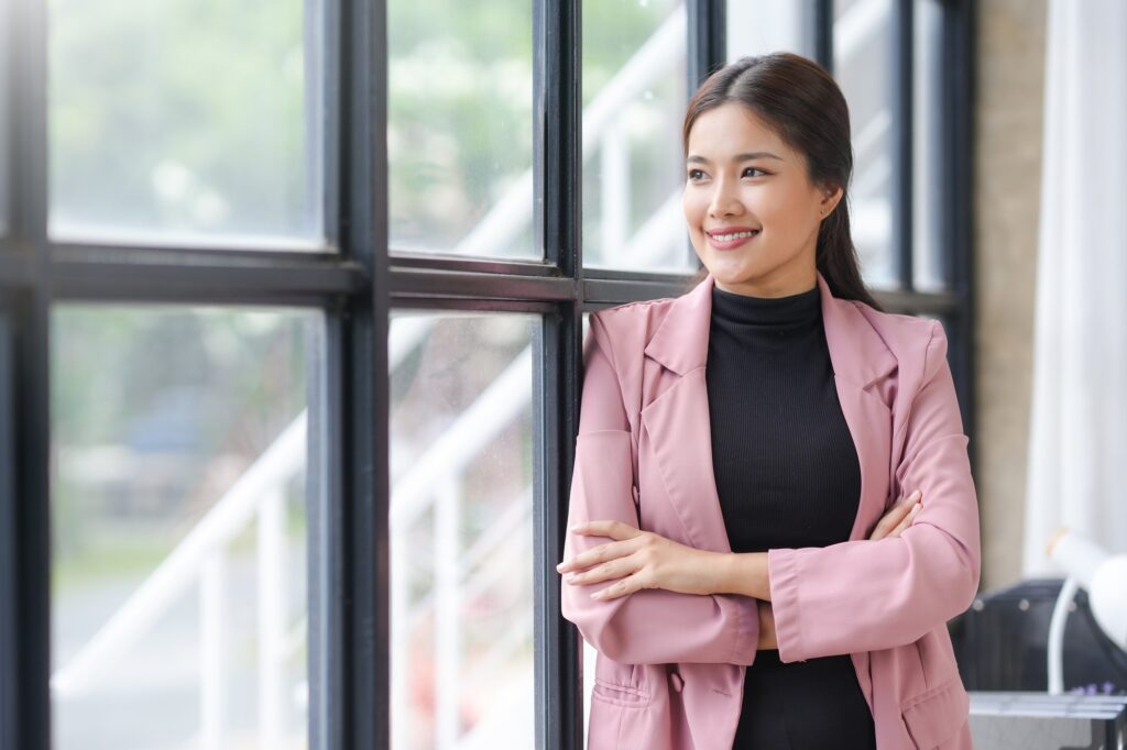 Successful businesswoman smiling and looking out of office window